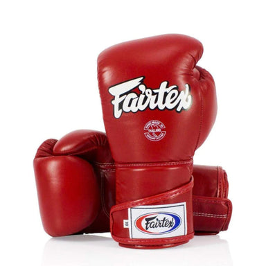 A pair of red leather boxing gloves with white and blue Fairtex branding, displayed on a clean white background.