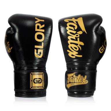 Black boxing gloves with gold 'Glory' and 'Fairtex' branding on a white background