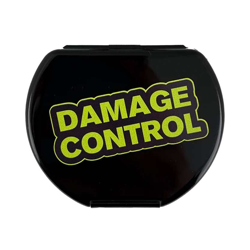 A glossy black oval compact or case featuring the words 'DAMAGE CONTROL' in bold lime green letters outlined in black, shown on a plain white background.