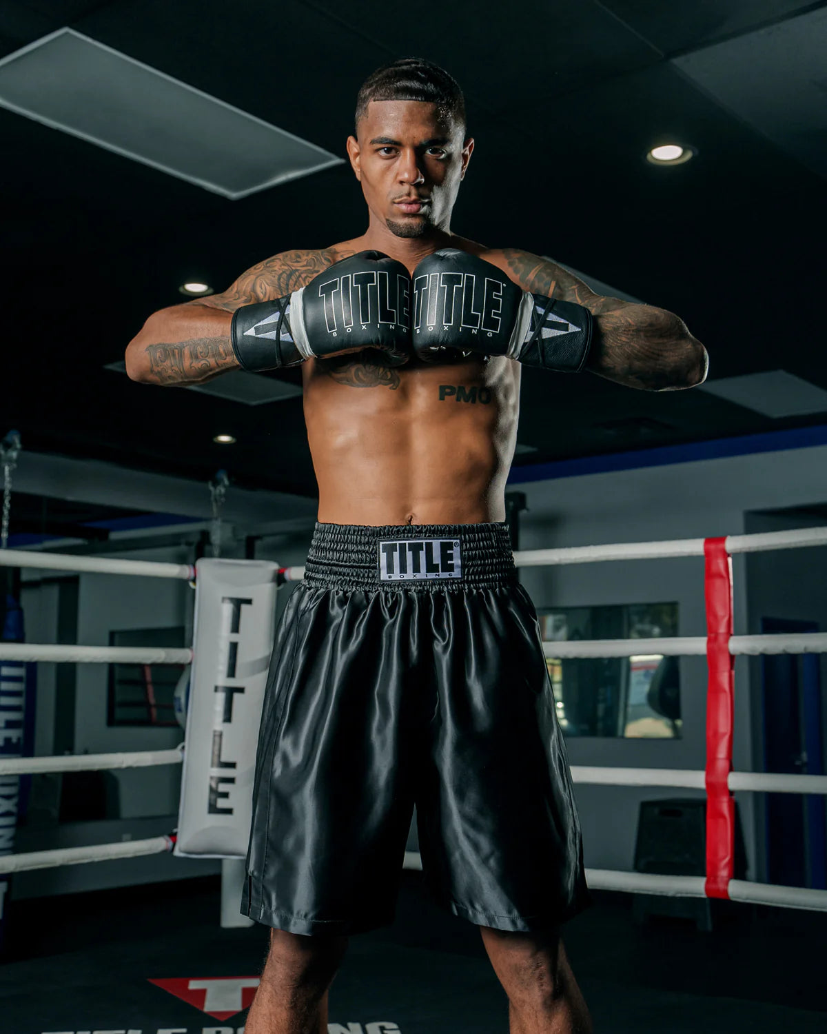 Boxer in a boxing ring wearing black boxing gloves and shorts with 'Title' branding.