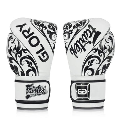 A pair of white and black Fairtex Glory boxing gloves shown from the back, featuring ornate black scrollwork patterns and the brand name 'GLORY' on the back, set against a plain white background.