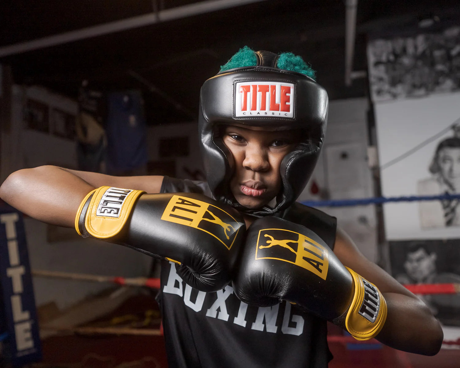 Young athlete wearing Title Classic black boxing headgear and gloves